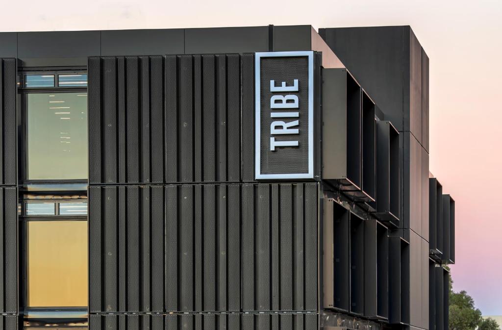a building with a street sign on top of it at Tribe Perth in Perth