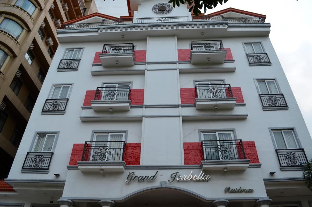 a tall white building with windows and a clock on it at Grand Isabella Residences in Cebu City