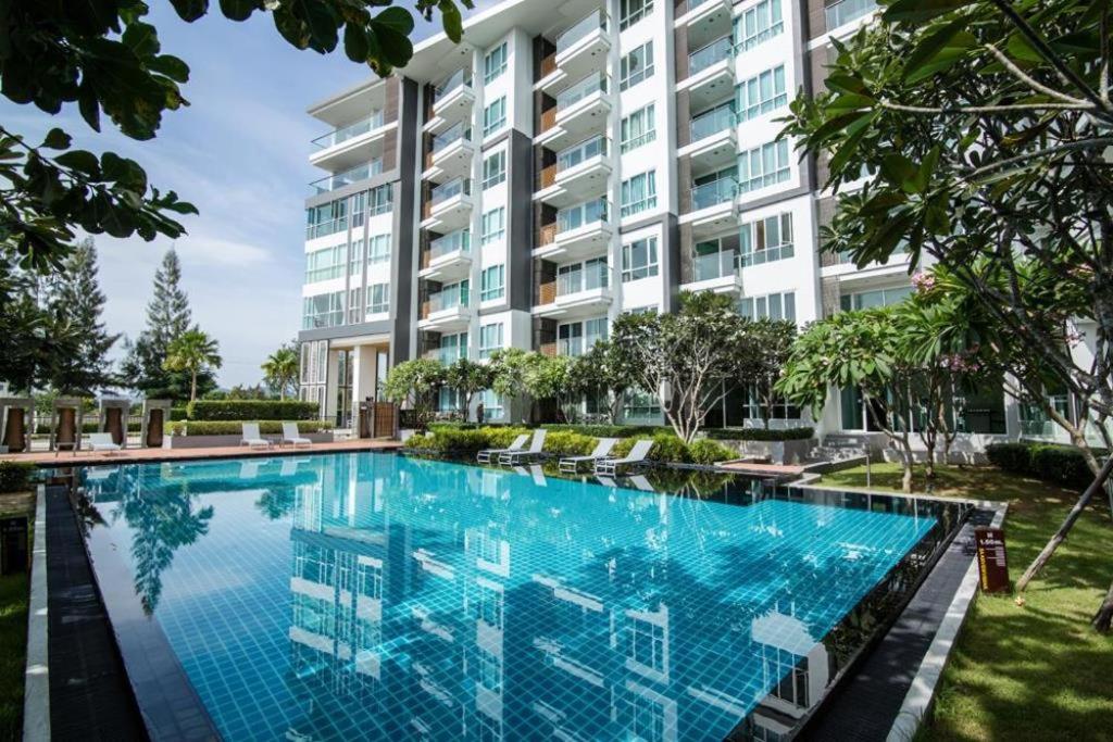 a swimming pool in front of a building at Ban View Viman Condo in Hua Hin
