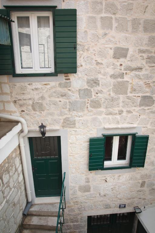 a stone building with green doors and windows at Bed & Breakfast Vila Baguc in Split