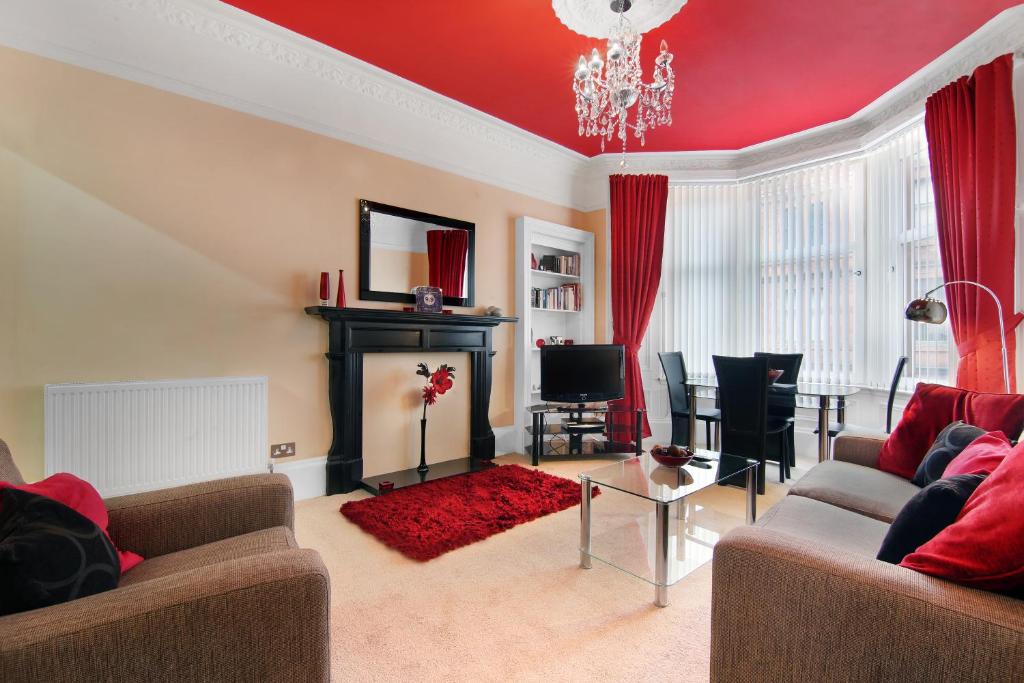 a living room with a couch and a fireplace at Townhead Apartments Glasgow Airport in Paisley