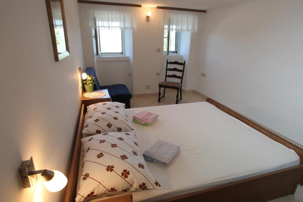 a bedroom with a bed and a room with a chair at Accommodation Lily in Vrana
