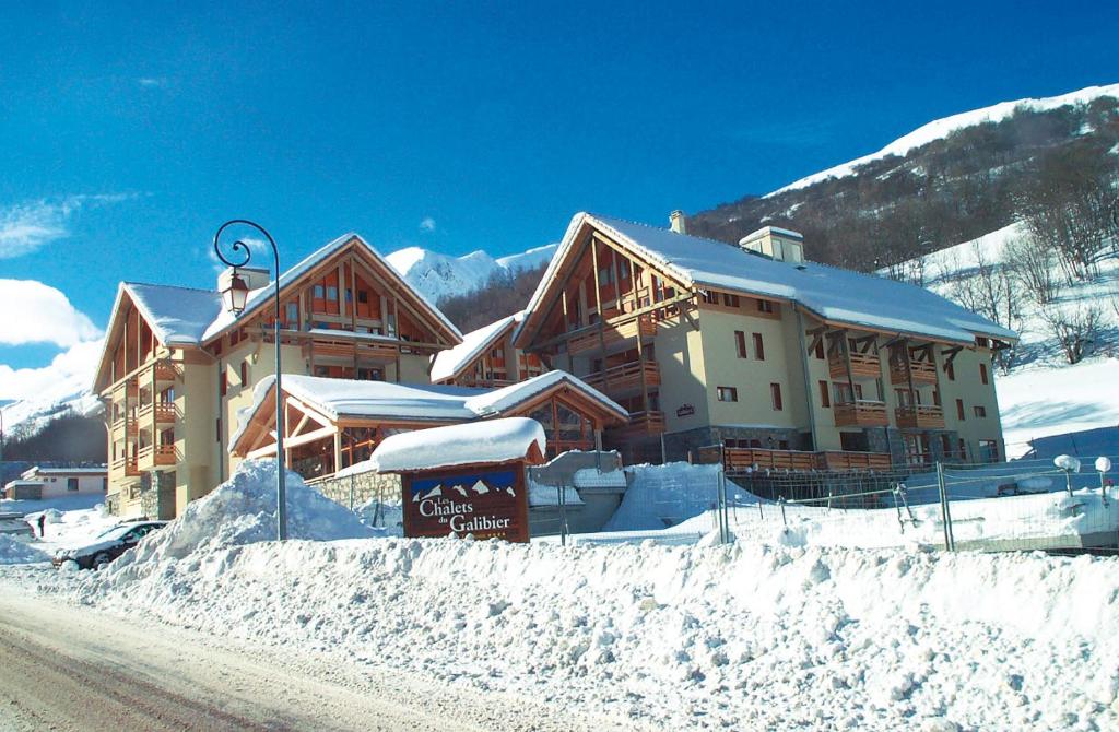 a lodge in the snow in front of a mountain at travelski home select - Résidence Les Chalets du Galibier 4 stars in Valloire