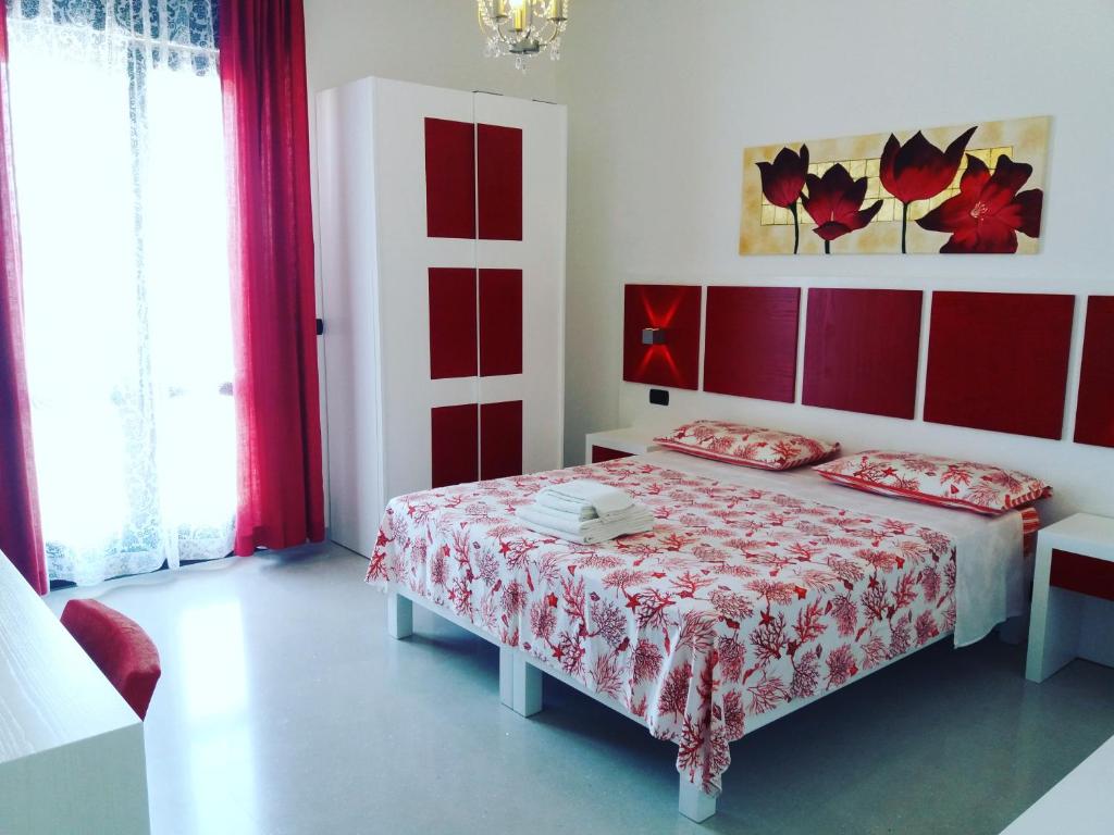 Schlafzimmer mit einem Bett mit rotem Kopfteil in der Unterkunft B&B Corallo in Capilungo