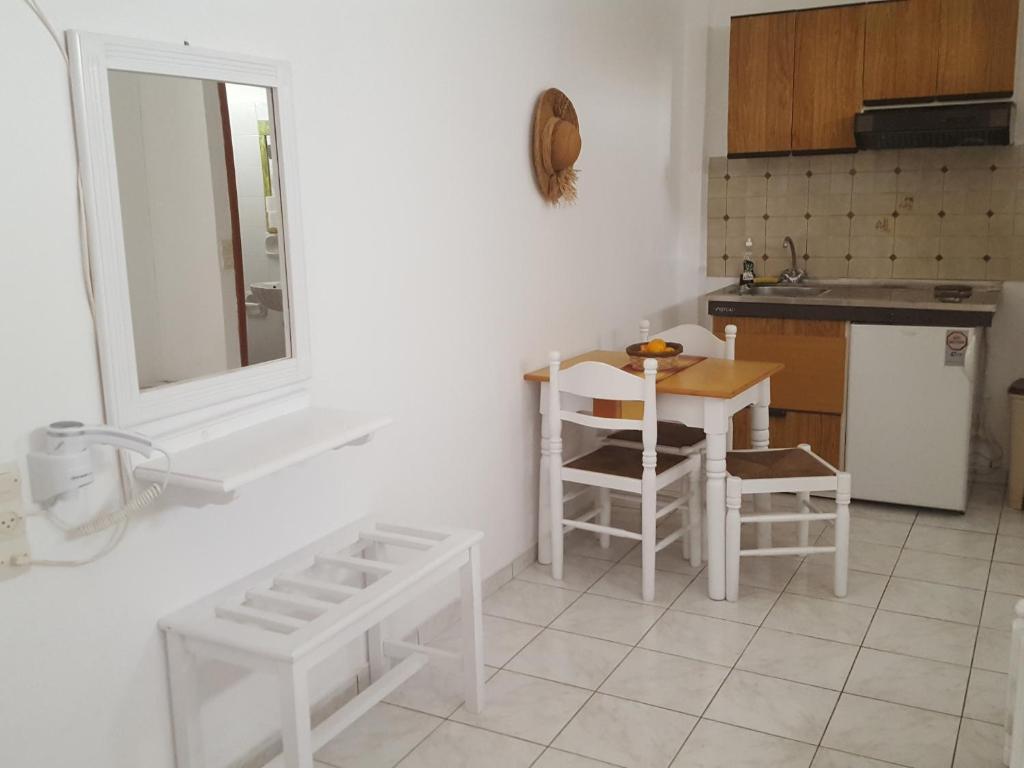 a white kitchen with a table and chairs in it at Aeolos Hotel Apartments in Gythio