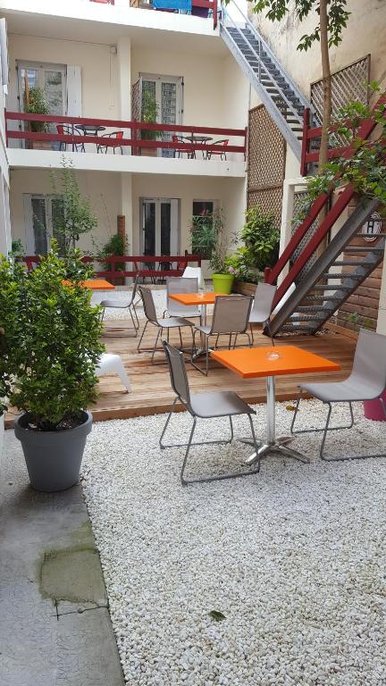 an outdoor patio with tables and chairs and a staircase at Hotel de Paris in La Rochelle