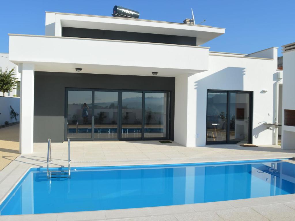 a house with a swimming pool in front of it at Modern villa with private swimming pool near Nazar in Famalicão