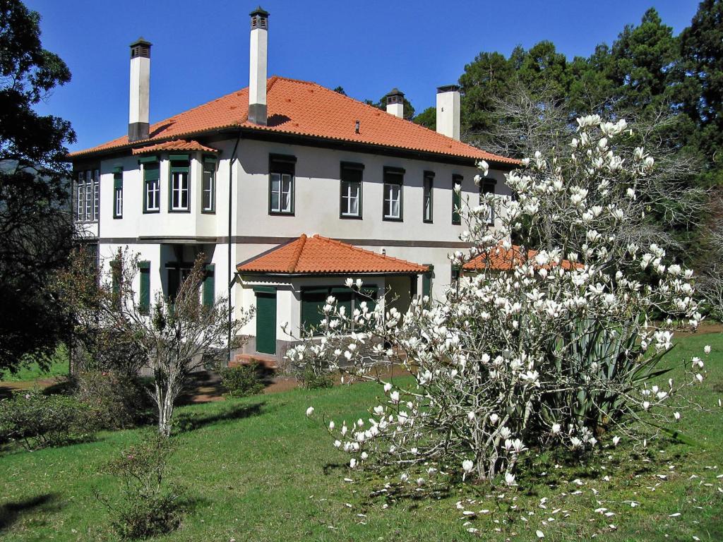 una casa grande con flores blancas delante en Beautiful house on the garden island of Madeira, en Santo da Serra