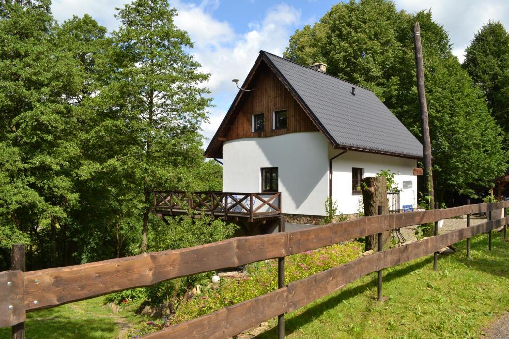 a house in a field with a fence at Trzy Strumyki in Kąty Bystrzyckie