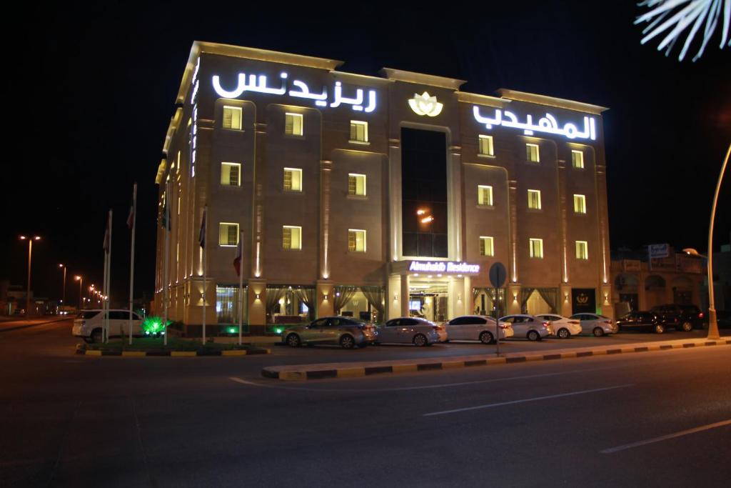 a hotel with cars parked in front of it at night at AlMuhaidb Residence Alkhafji in Al Khafji