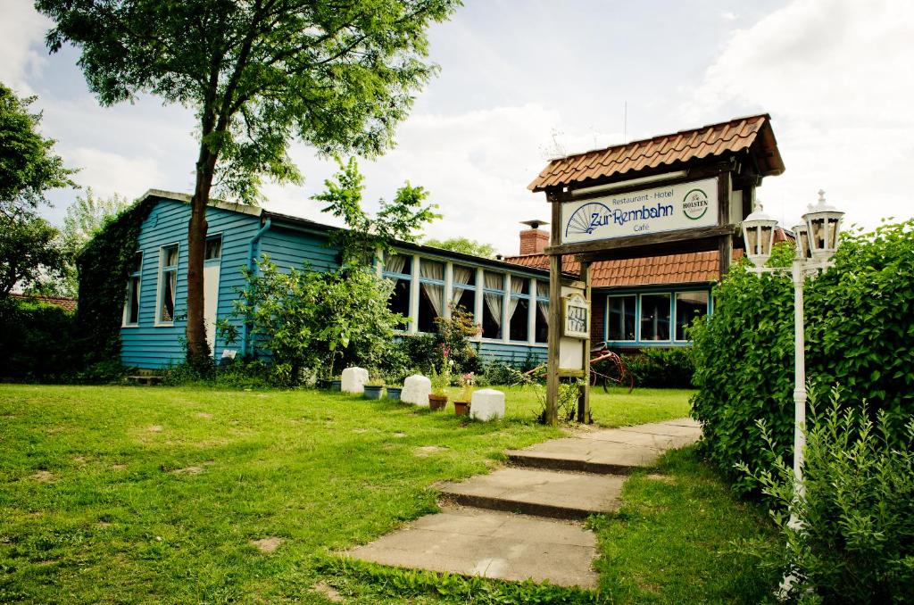 ein blaues Gebäude mit einem Schild davor in der Unterkunft Zur Rennbahn in Drage