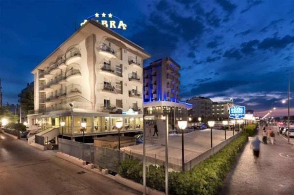 a large building with a sign on top of it at Hotel Ambra in Rimini