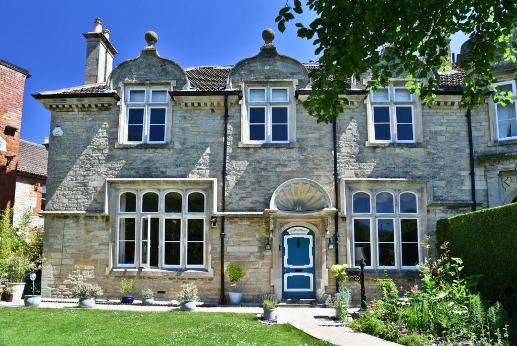 an old stone house with a blue door at Heritage Bed and Breakfast in Calne