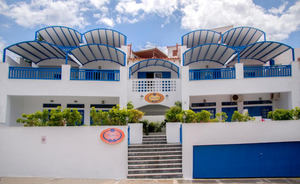 - un bâtiment blanc avec des portes et des escaliers bleus dans l'établissement Erato Apartments, à Batsi