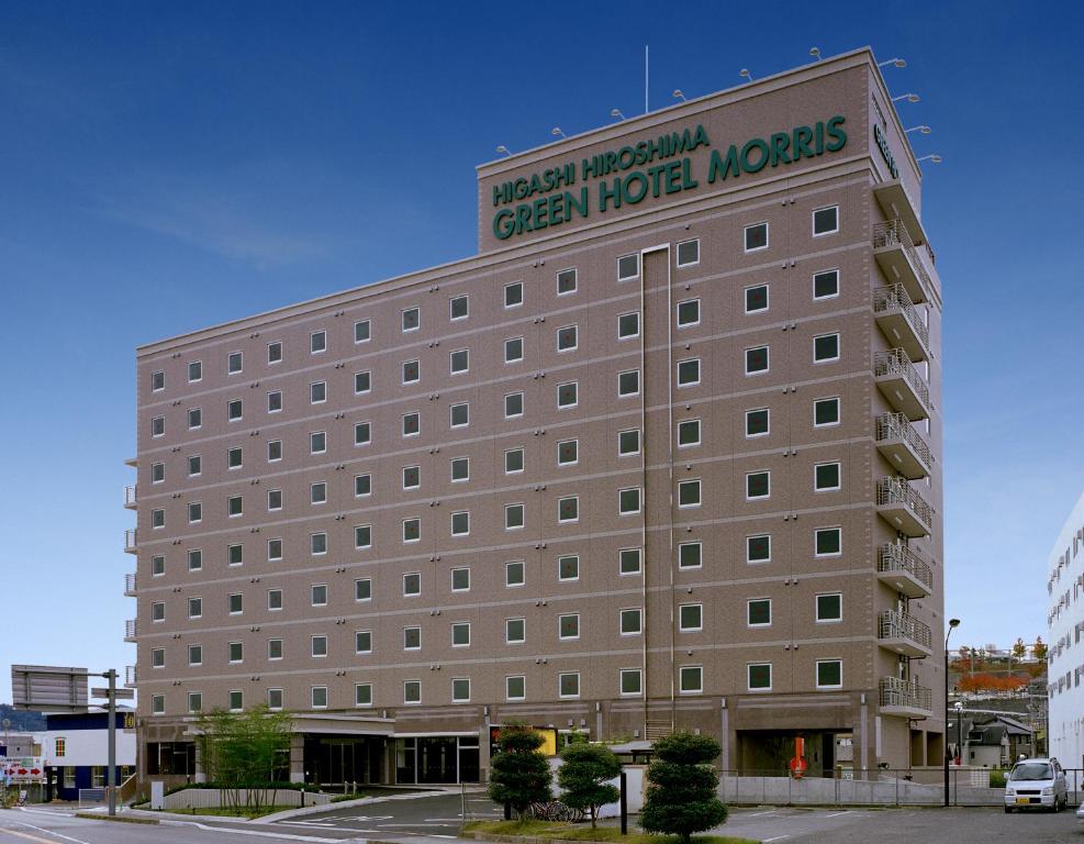 un grand bâtiment avec un panneau en haut dans l'établissement Higashi Hiroshima Green Hotel Morris, à Higashihiroshima