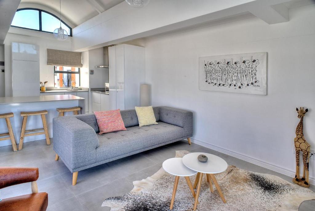 uma sala de estar com um sofá e uma mesa em Azure 216 em Bloubergstrand