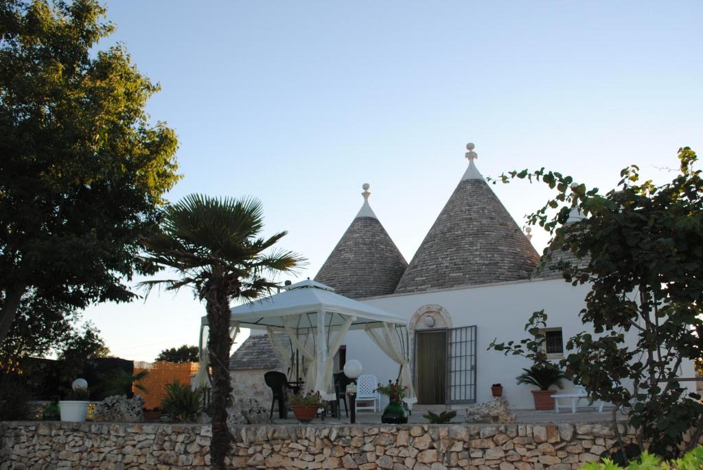 a white house with two towers on top of a wall at Trullo Pietraluna in Martina Franca