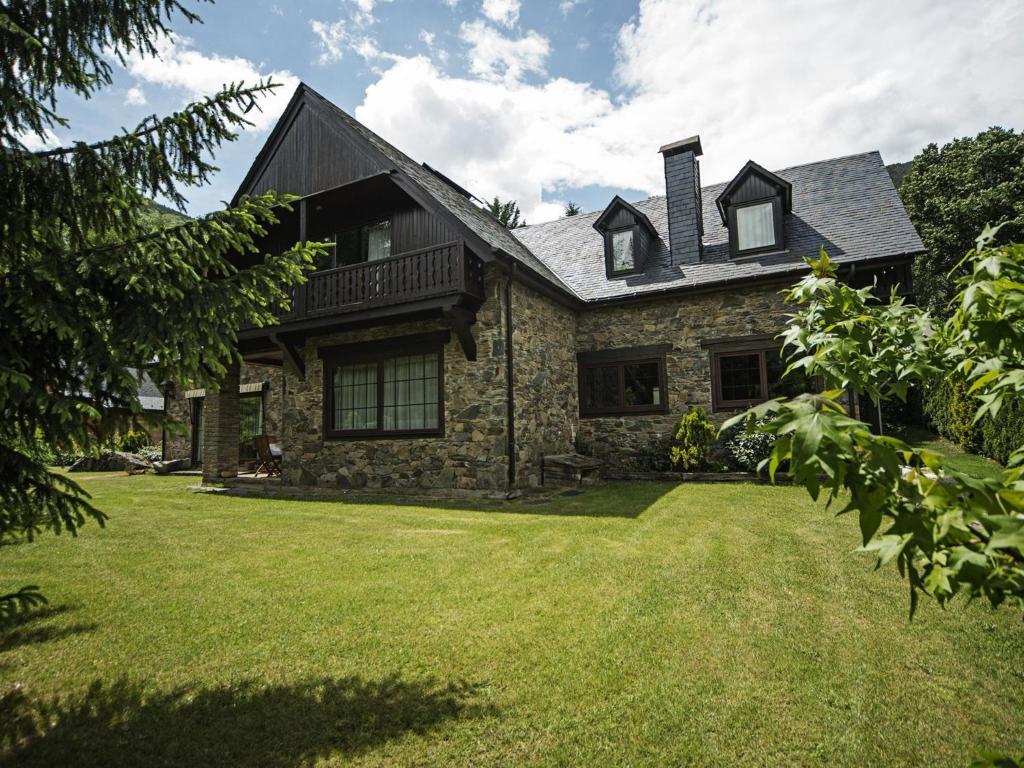 a stone house with a grass yard at Chalet in Vielha near Baqueira Ski Resort in Vielha