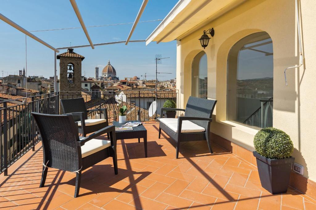 Un patio con sillas y una mesa en el balcón. en Apartments Florence La terrazza, en Florencia