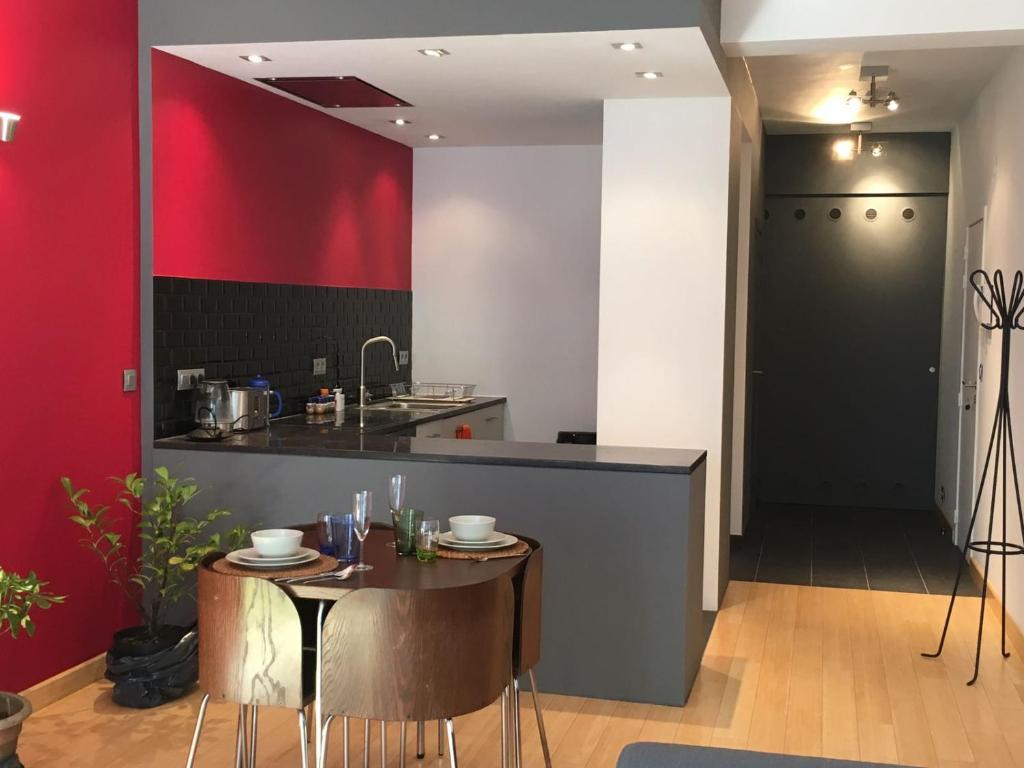 una cucina con tavolo e parete rossa di Gachard a Bruxelles