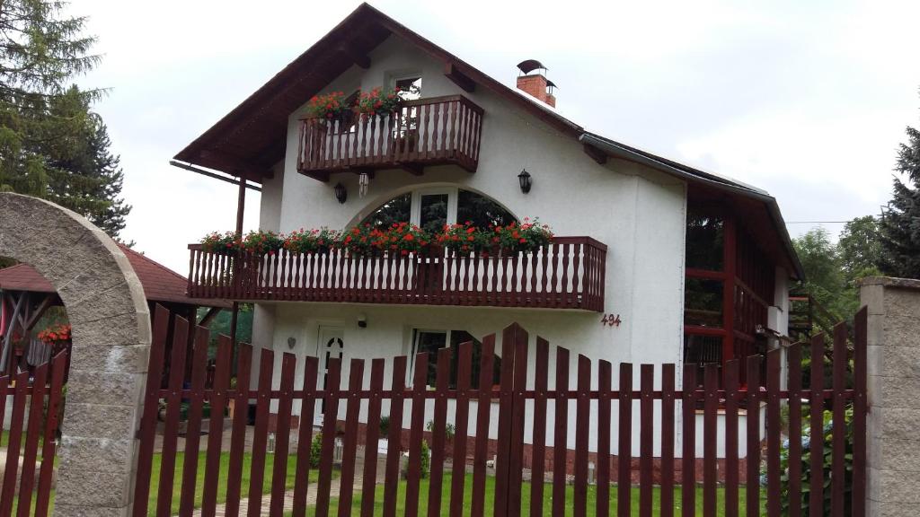 ein Haus mit zwei Balkonen und einem roten Zaun in der Unterkunft APARTMAN Marcela in Libouchec