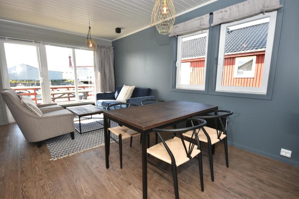 a living room with a dining room table and chairs at Lankanholmen in Andenes