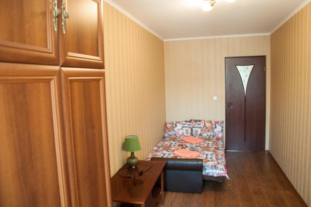 - une chambre avec un lit, une table et une porte dans l'établissement Apartments on Svobody 39, à Oujhorod