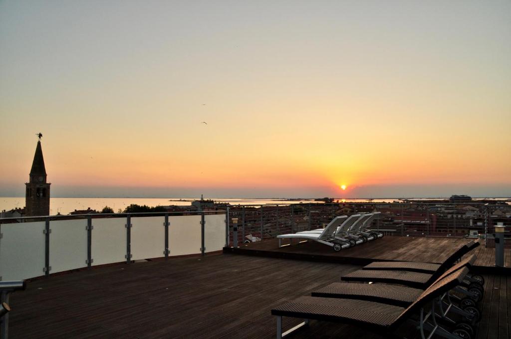 Blick auf den Sonnenuntergang von der Terrasse eines Gebäudes in der Unterkunft Hotel Regina in Grado