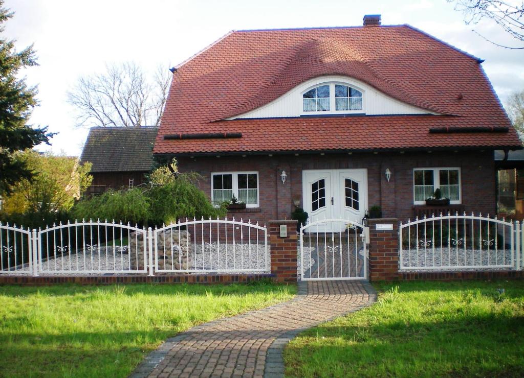 einen weißen Zaun vor einem Haus in der Unterkunft Spreewald-Ferienwohnung Reschke in Radensdorf
