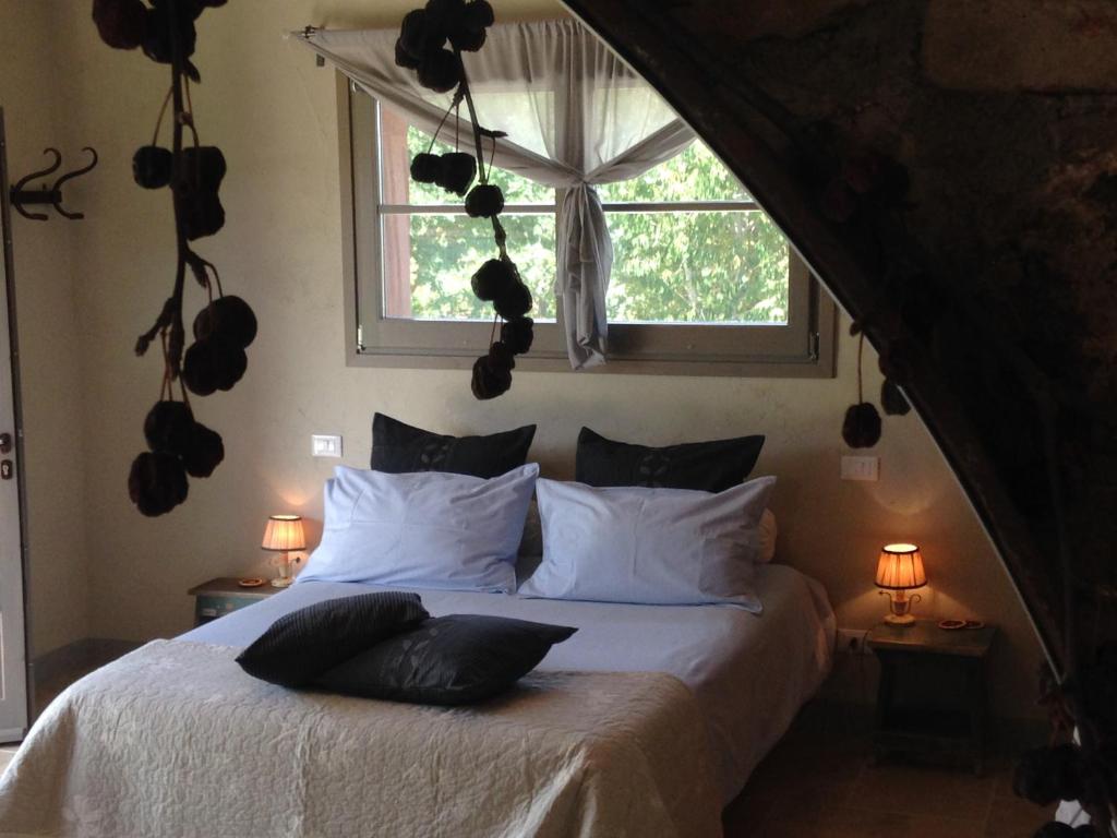 Le Palazze B&b في تشيوسي: غرفة نوم بسرير وملاءات بيضاء ونافذة