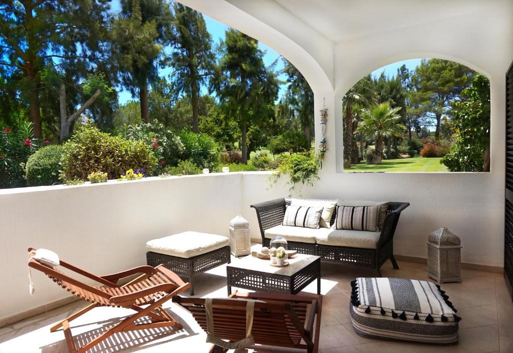 een patio met stoelen, een bank en een tafel bij Palmeira VIP Apartment in Portimão