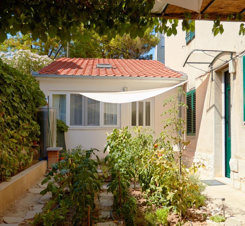 a garden in front of a house with a roof at Studio Apartman Kaćunić in Split