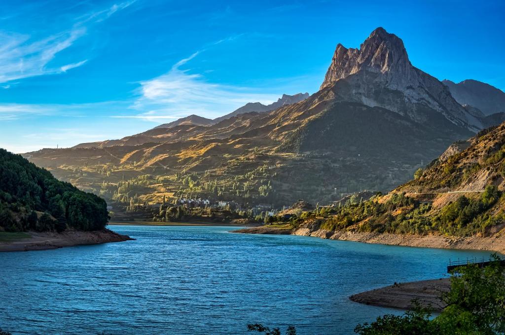 vistas a un río con montañas en el fondo en Aparthotel Sarrato, en Sallent de Gállego