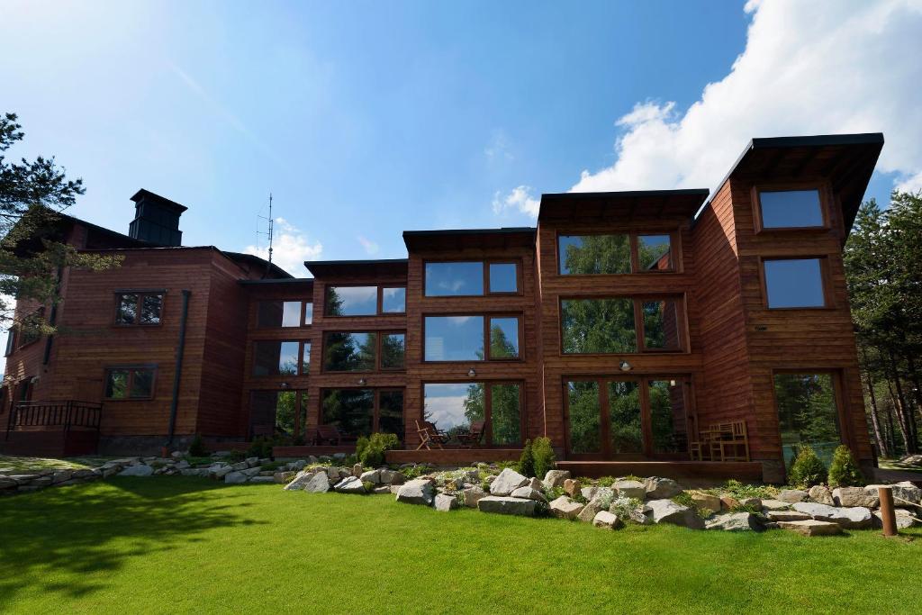 una gran casa de madera con un patio verde en PinusVillas Conference Lodge en Zheleznitsa