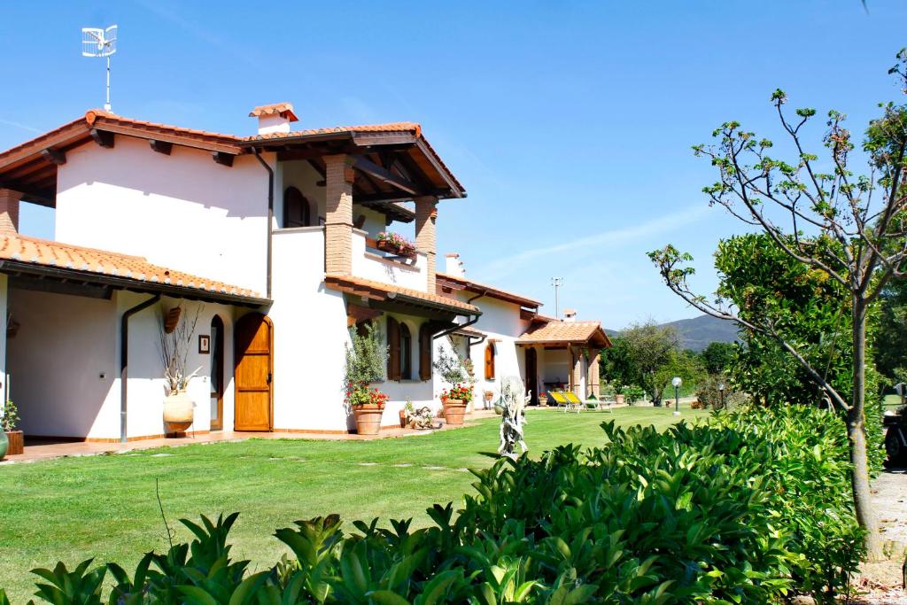 ein großes weißes Haus mit einem Hof in der Unterkunft La Vecchia Fornace in Castiglione della Pescaia