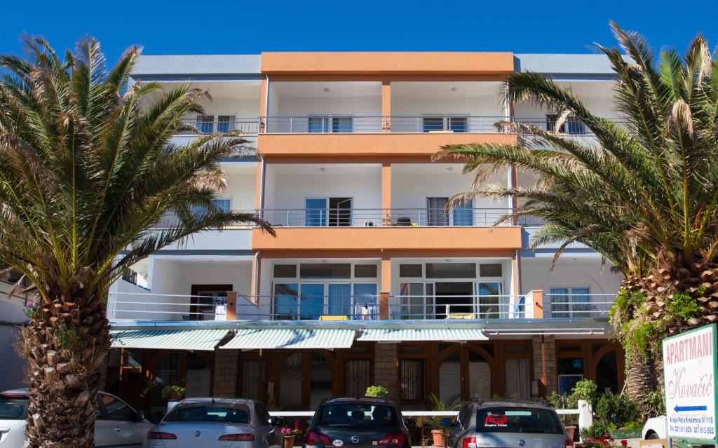 a large building with palm trees and palm trees at Apartments Kovačić in Makarska