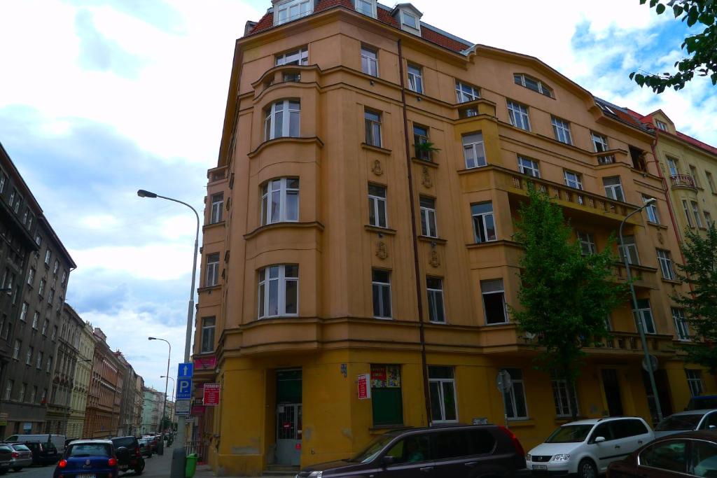 プラハにあるCozy modest room for 2 or 3 personsの車が目の前に停まった高い黄色の建物