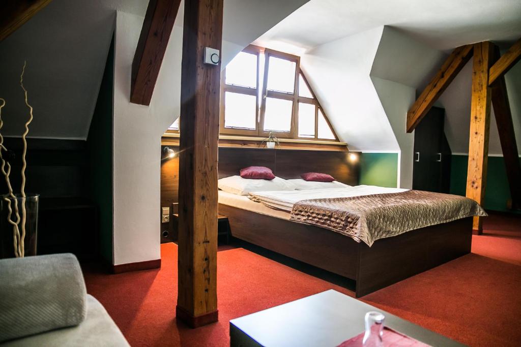 オストラヴァにあるHotel Bestのベッドルーム1室(屋根裏部屋に大型ベッド1台付)