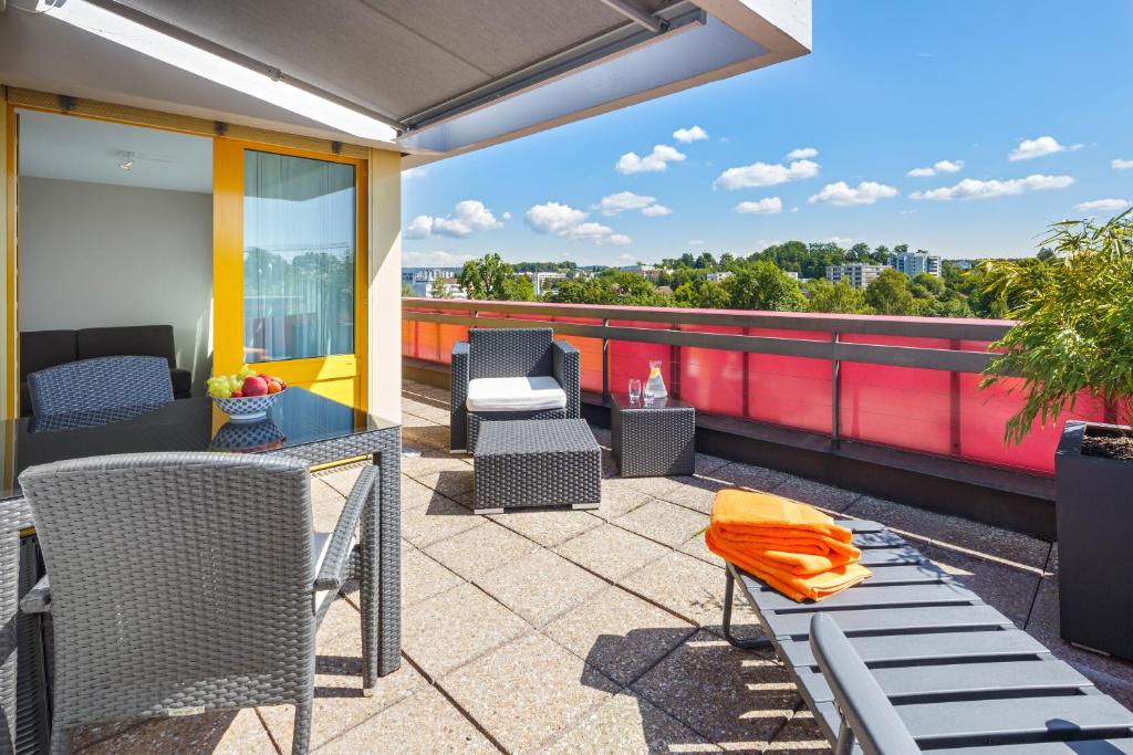 a patio with a table and chairs on a roof at achesa homes in Glattbrugg