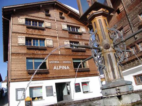 un bâtiment avec un poteau en face de celui-ci dans l'établissement Apartment Alpina, à Brigels