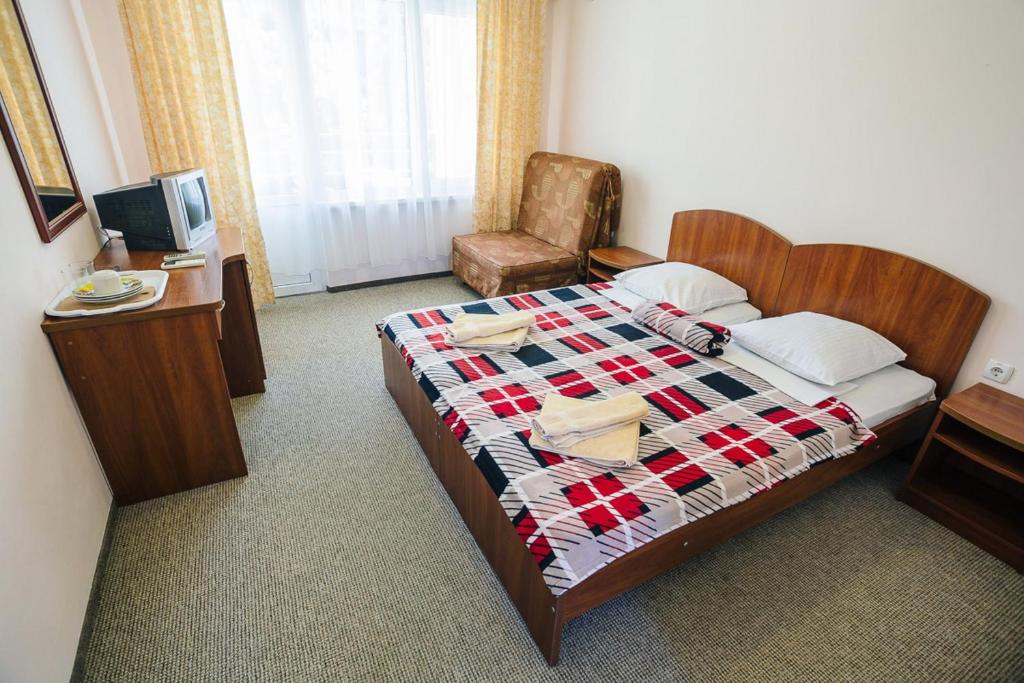 a hotel room with a bed and a chair at Tvorcheskaya Volna Resort in Koktebel