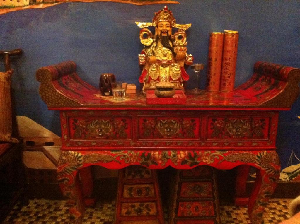 a wooden table with a statue on top of it at Kevin's Old House in Shanghai