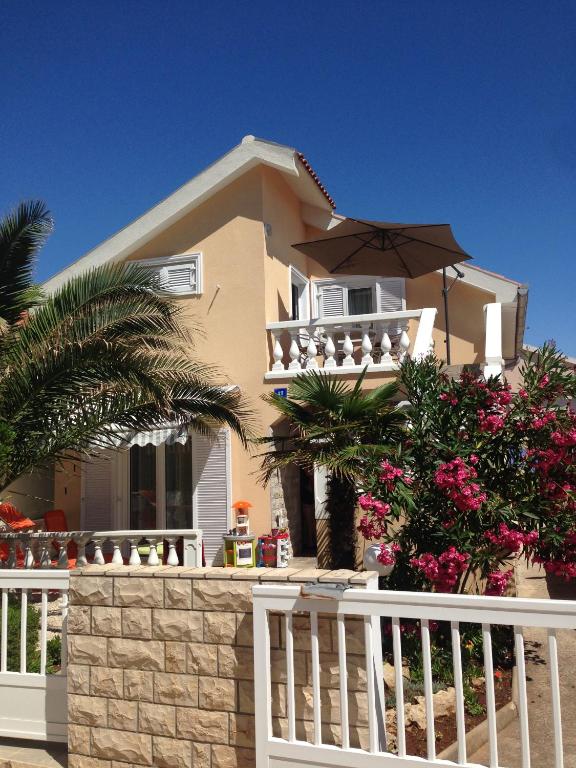 a house with a white fence in front of it at Apartment Vujic in Vir