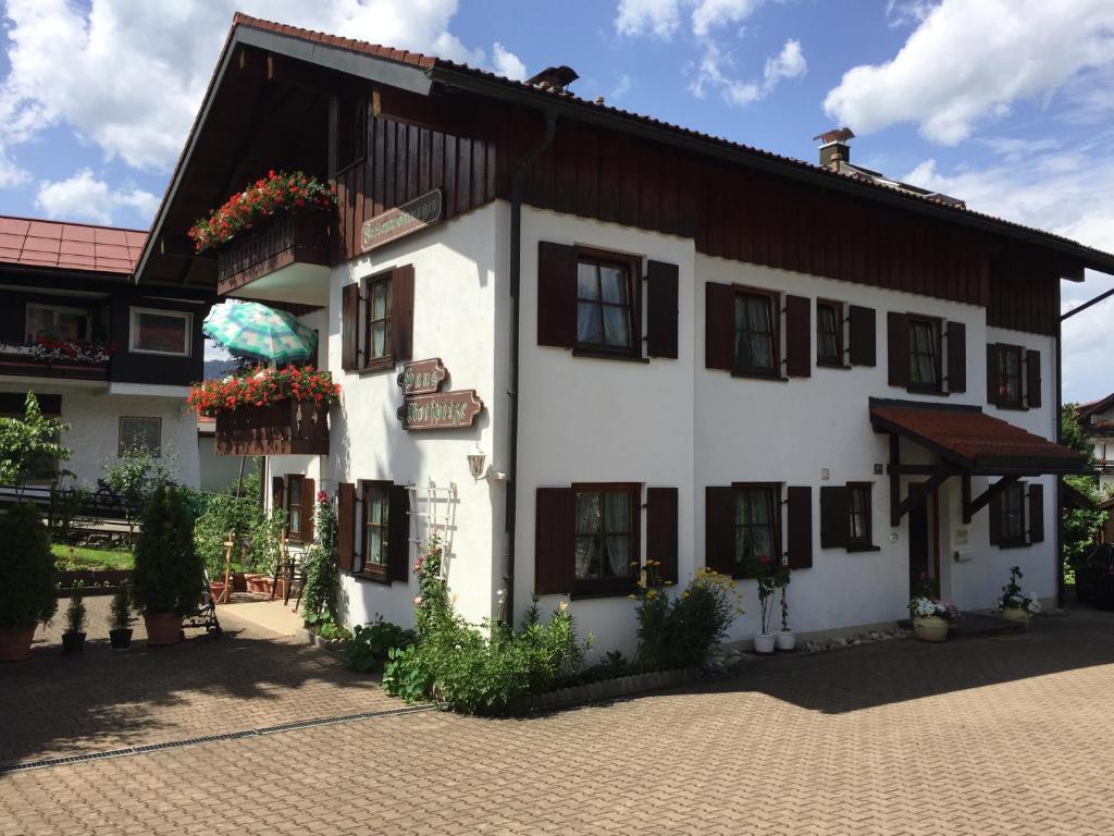 biały budynek z czarnymi oknami i kwiatami w obiekcie Haus Rotspitze w mieście Oberstdorf