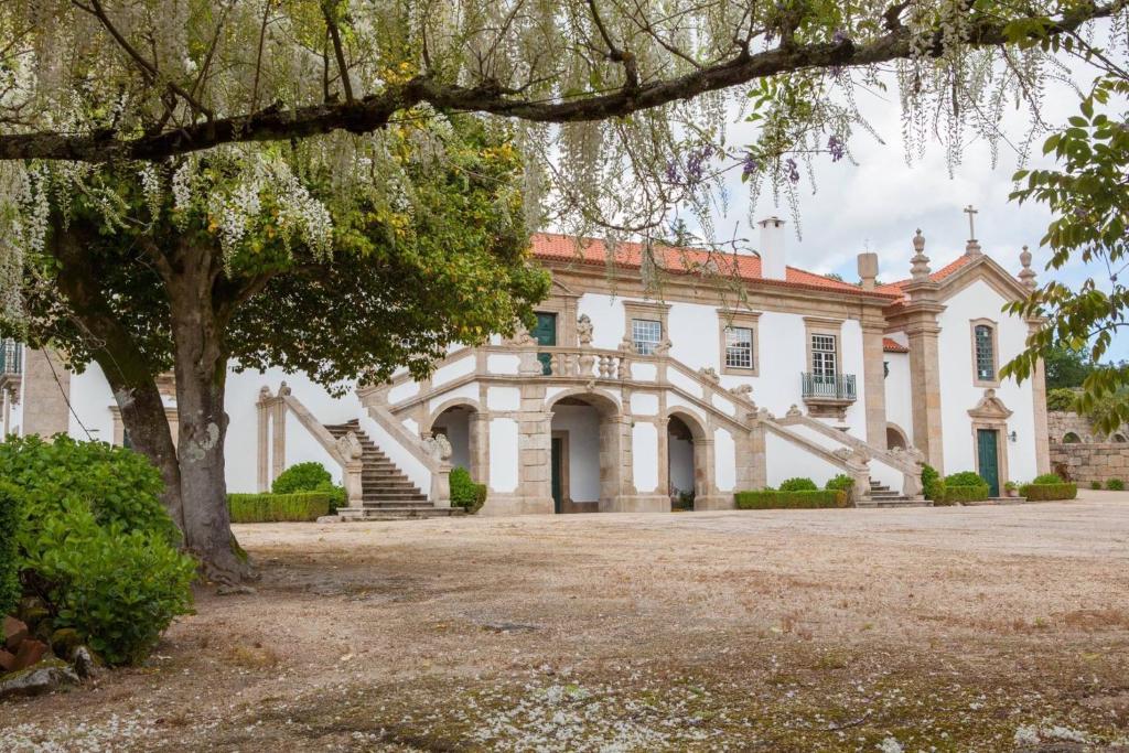 una vecchia casa con un albero di fronte di Casa de Quintã a Marco de Canaveses