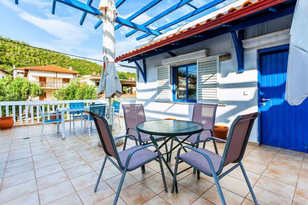 a patio with a table and chairs on a balcony at Xenios Loutra Village Arsinoi Studios in Agia Paraskevi