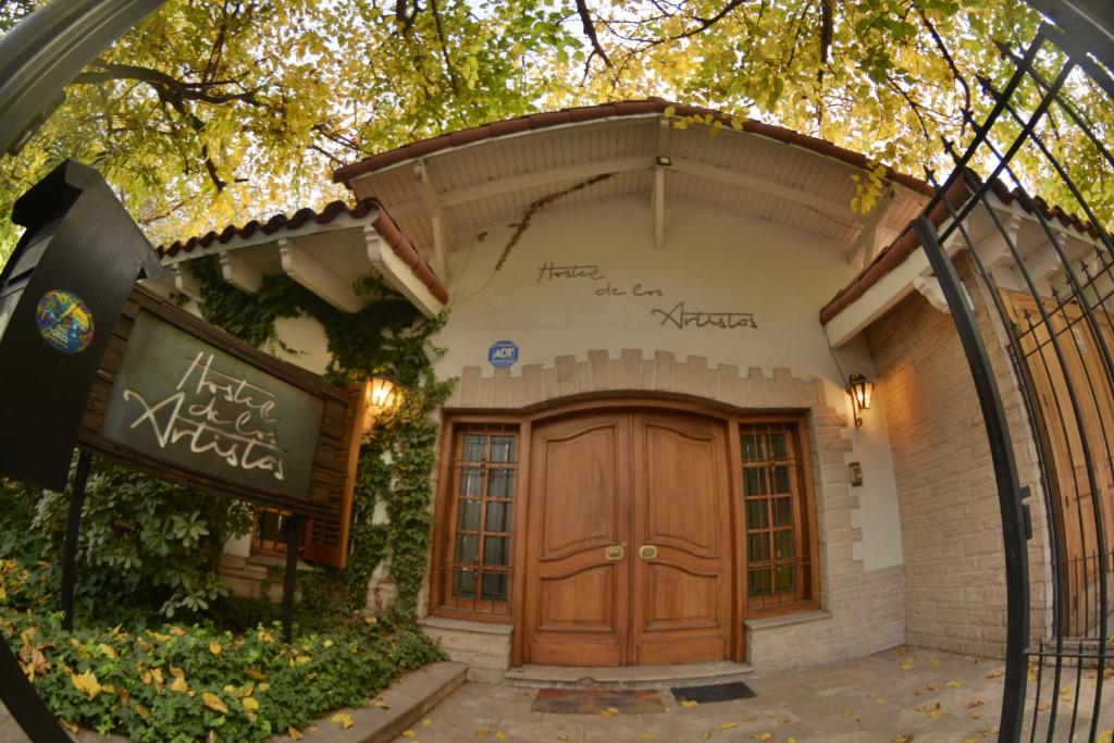 een huis met een houten deur ervoor bij Hostel de Los Artistas in Mendoza