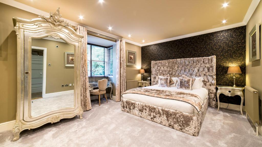 a bedroom with a large bed and a large mirror at Derby Manor in Bournemouth