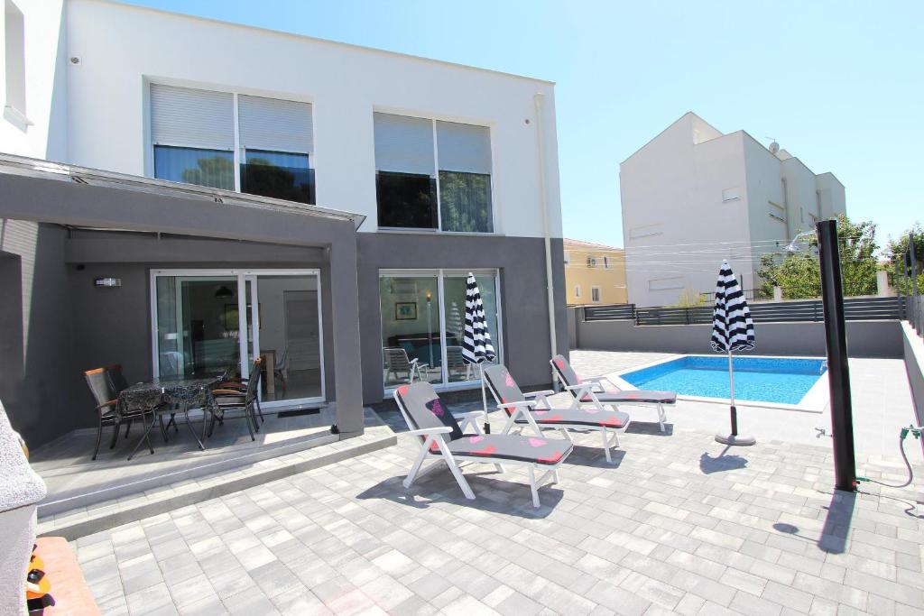 a patio with lounge chairs and a swimming pool at Apartment Karlo 2 in Rovinj