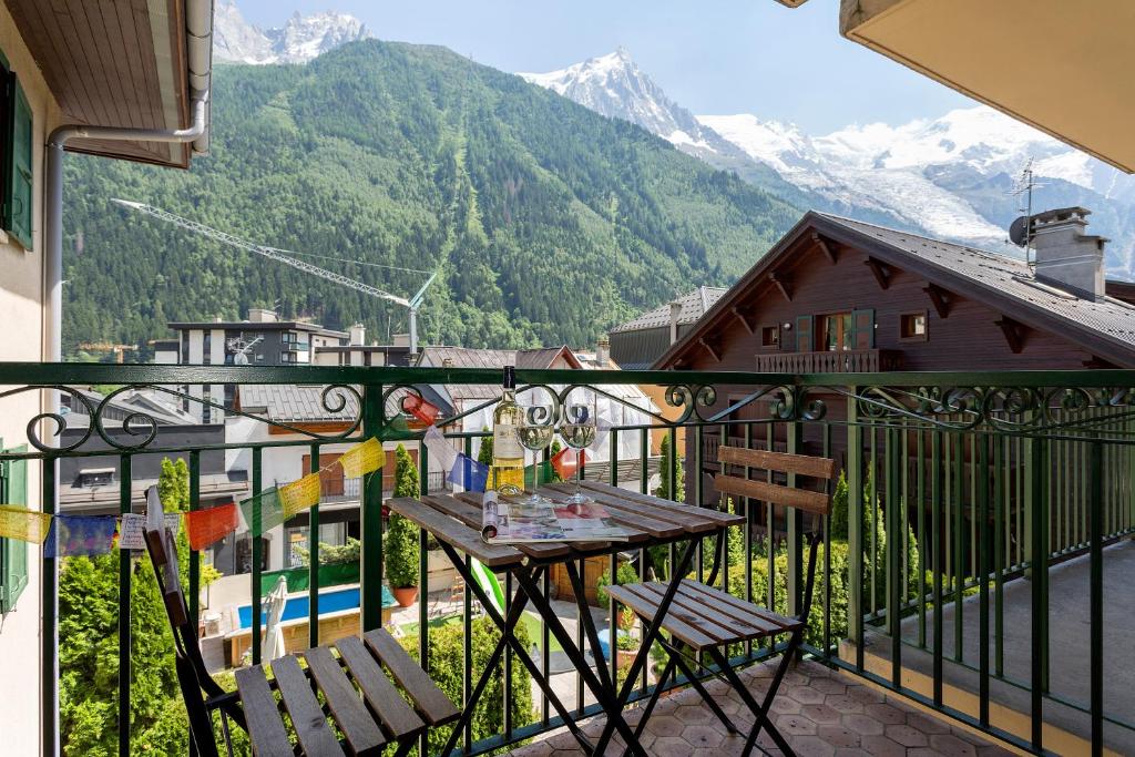a balcony with a table and chairs and mountains at Apartment Blanc Neige 2 in Chamonix-Mont-Blanc
